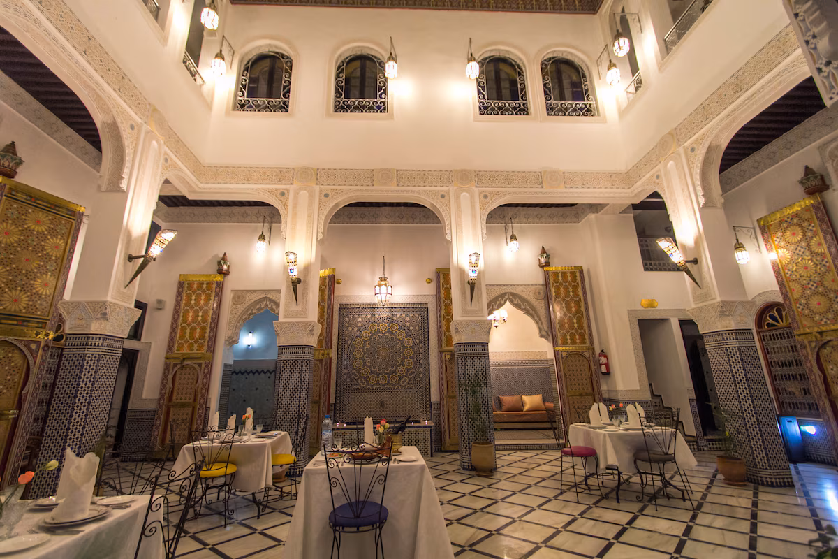 Salon-restaurant du riad sous les arcades éclairées de lanternes